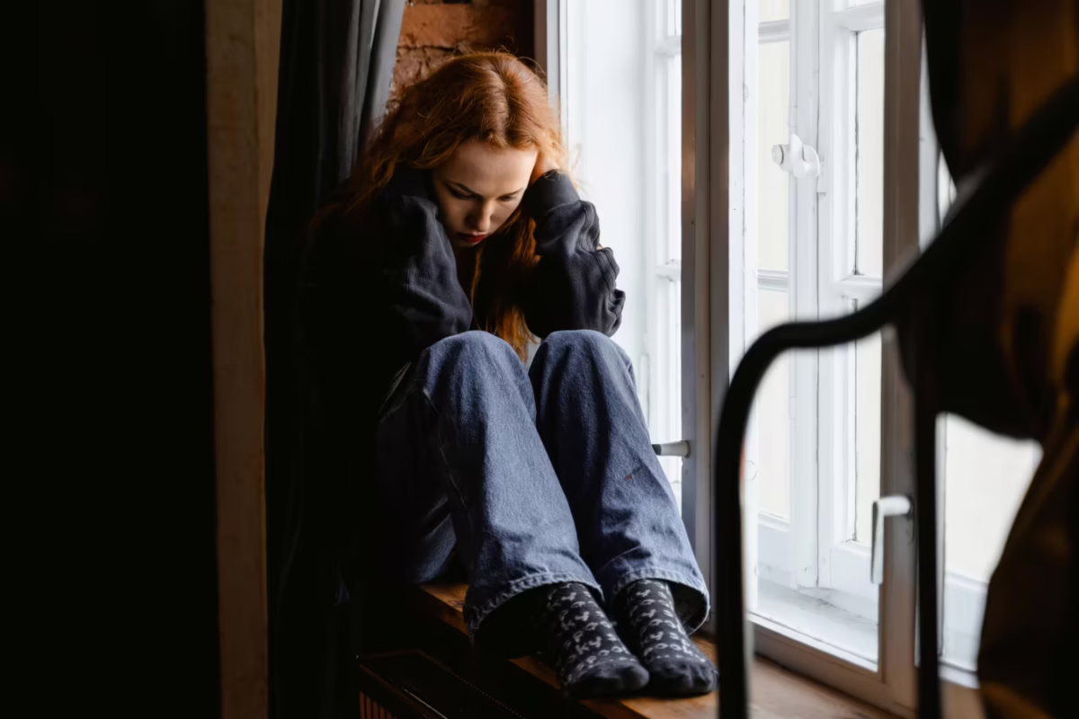 Woman struggling with negative thoughts that are preventing her from staying motivated.