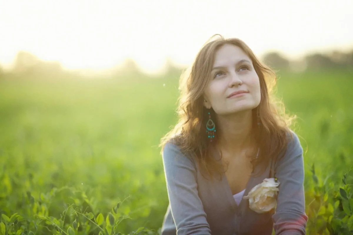 Woman looking at the sky, believing in something higher.