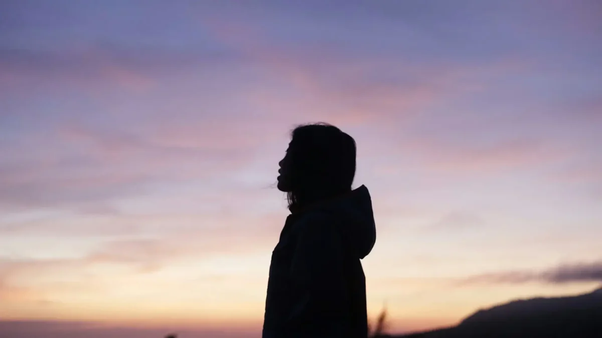 Woman in sunset being grateful.