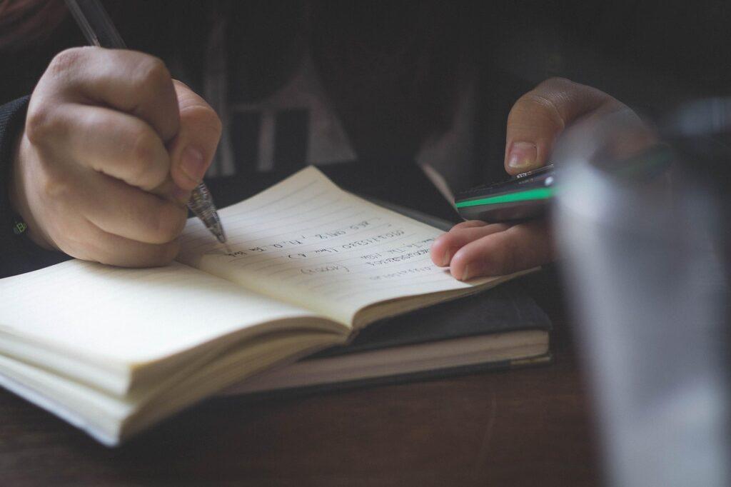 Person writing down how the visualize their future in order to achieve their goals in life.