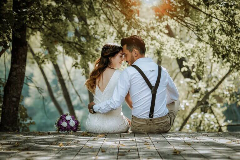 Happy couple that followed healthy relationship tips, sitting on a forest path, hugged.