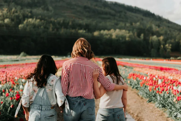 Women holding each other in a field, representing scientific facts about women.