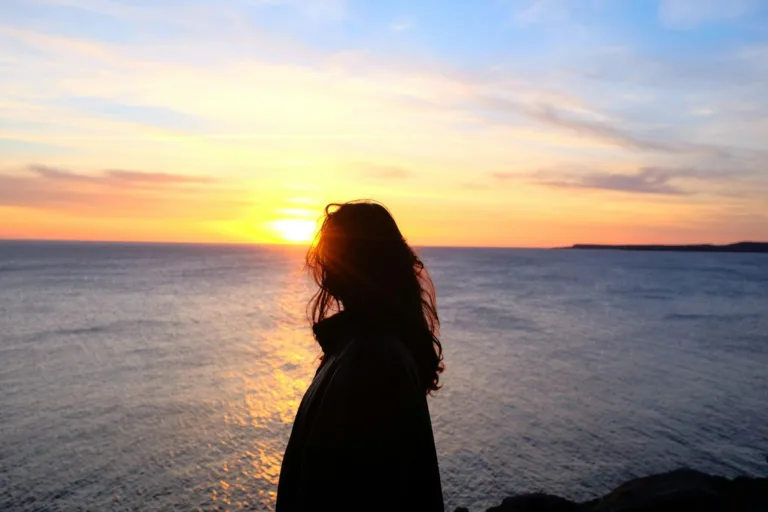 Woman in sunset reflecting on her self discovery journey through self discovery questions.