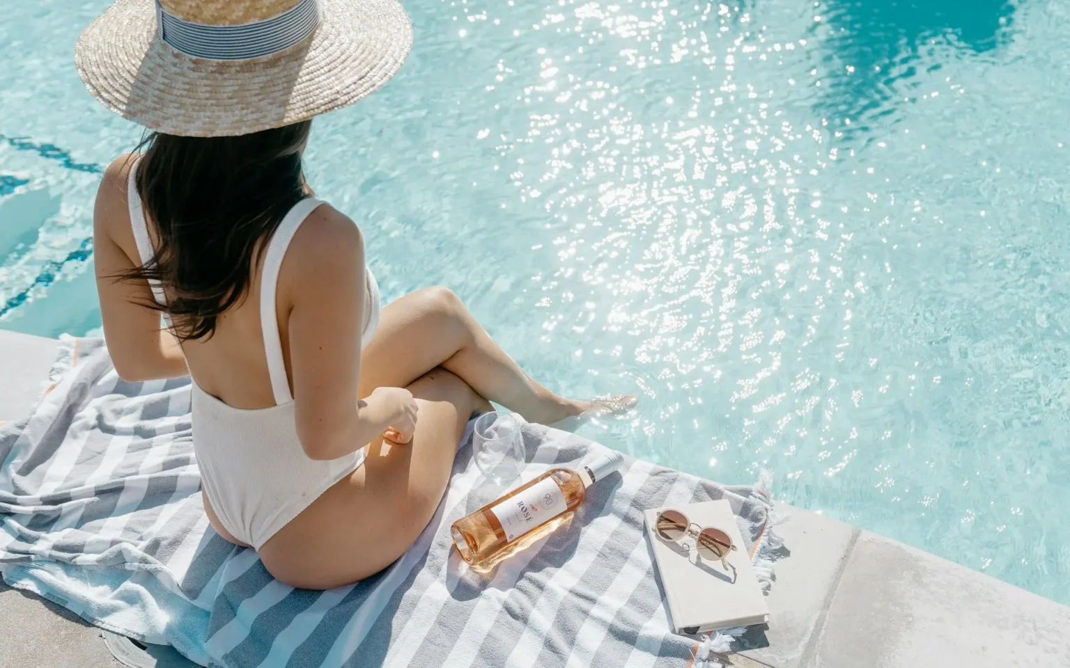 Woman on a beach enjoying her summer self-care essentials.