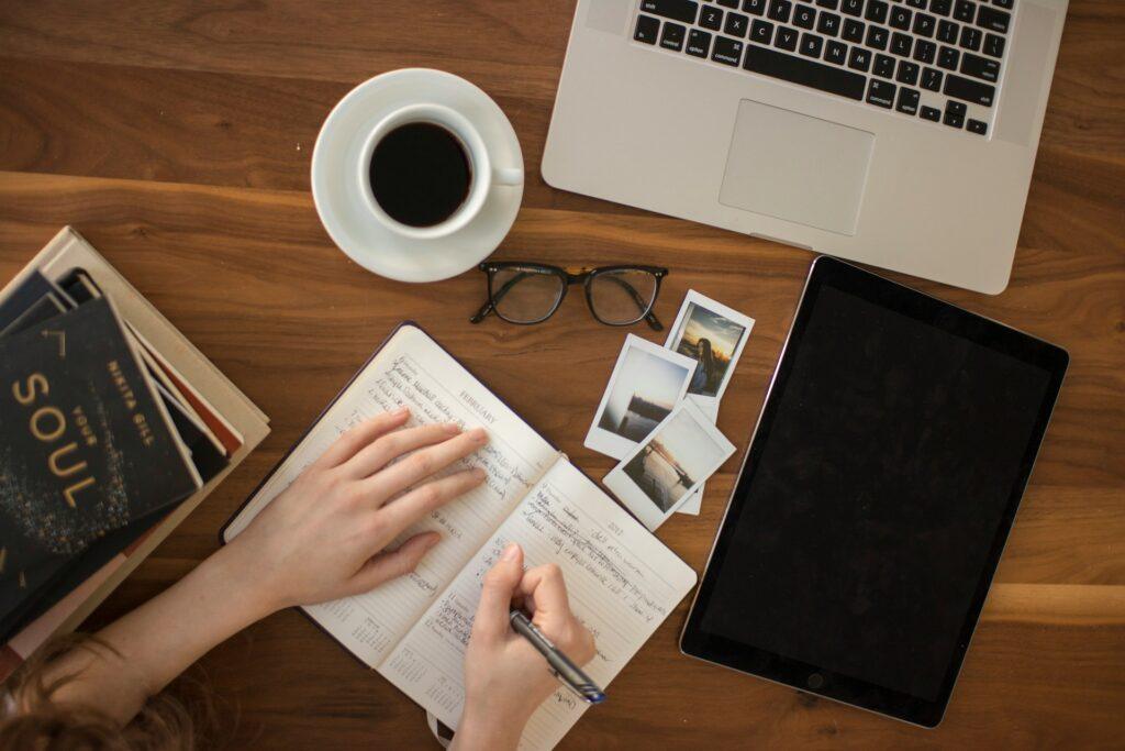 Person journaling on a desk, as one of the good good habits to have.