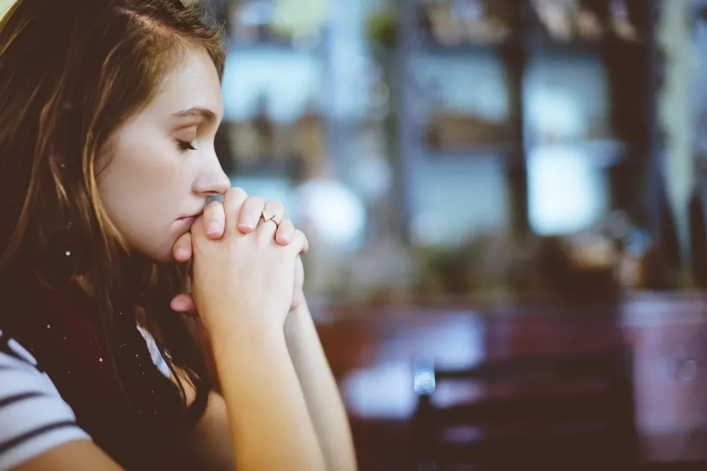 Woman with her hands together, representing accepting what is out of her control as a part of her anxiety relief practice.