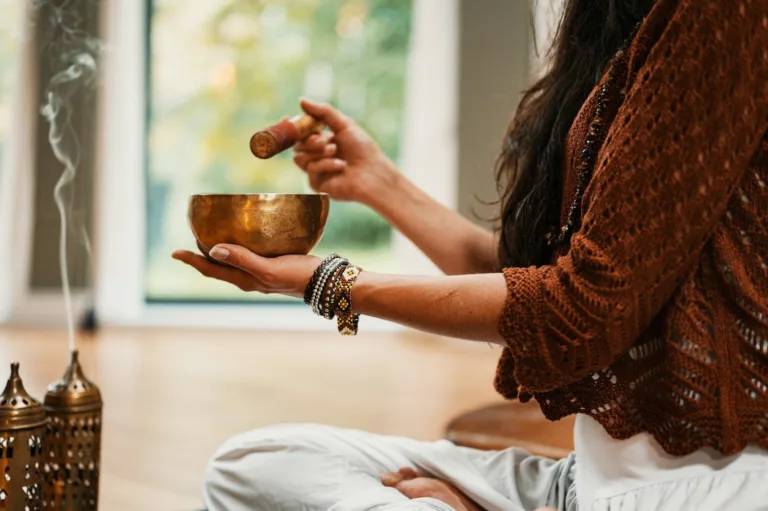 Woman using Sound Healing Crystal Singing Bowls as a part of her healing therapy and energy healing practice.