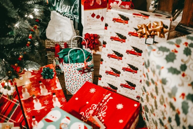 Secret Santa gifts for coworkers and friends under a Christmas tree.