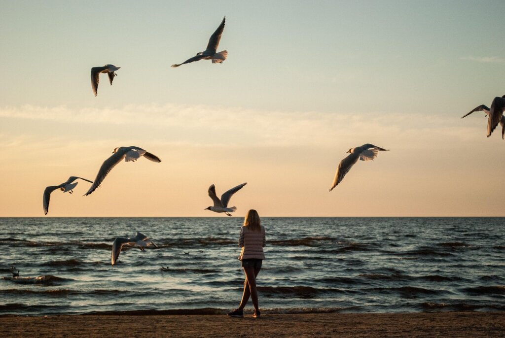 Woman on a beach, representing self-reflection and a decision to change environments in order to become a better version of yourself.