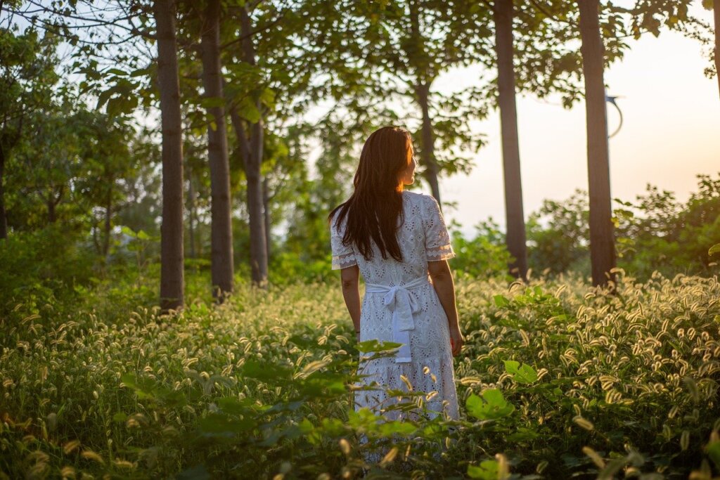 Woman in a field of flowers, representing growth that happens when reinventing yourself.