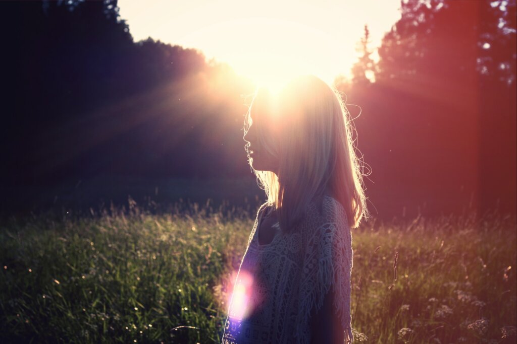 Woman with sunlight on her face, representing mindset growth.