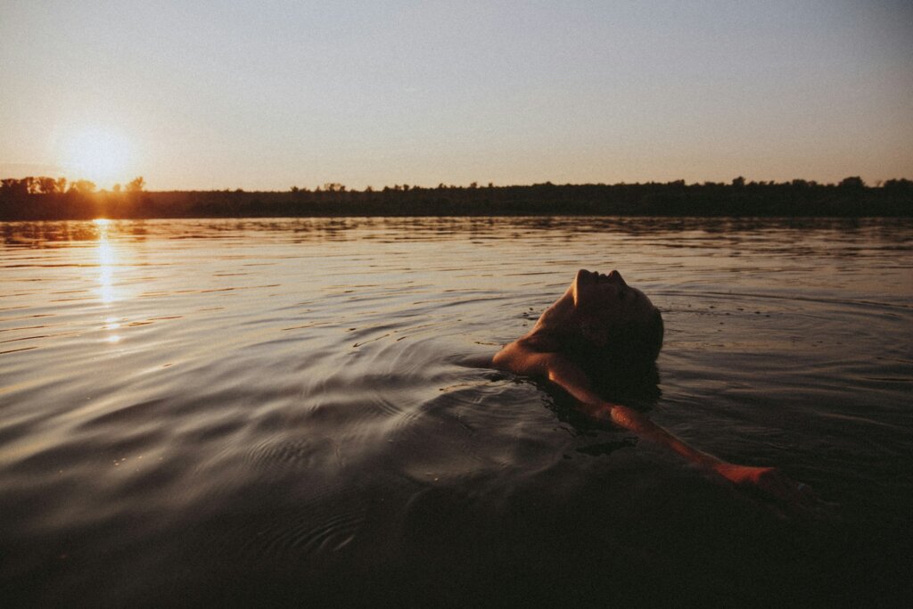 Woman swimming in the ocean, reflecting on how to feel better about life.