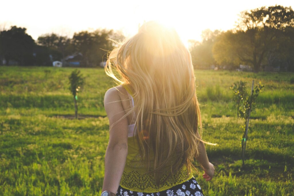 Woman running toward the sunlight, representing mindset growth.