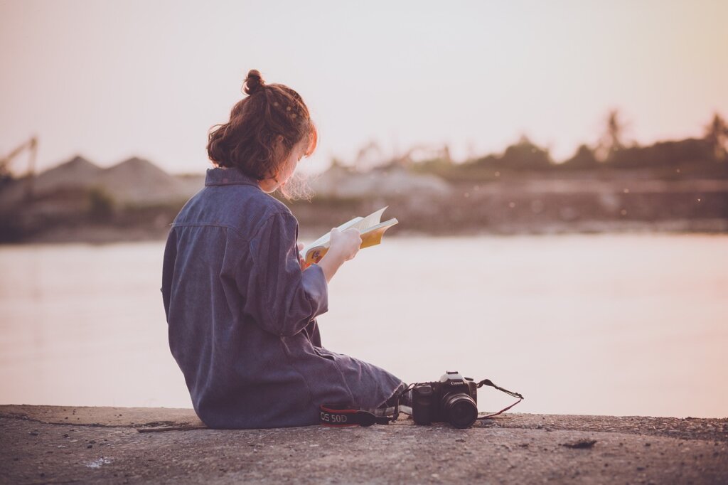 Woman reading a book, learning more about how to reinvent yourself.