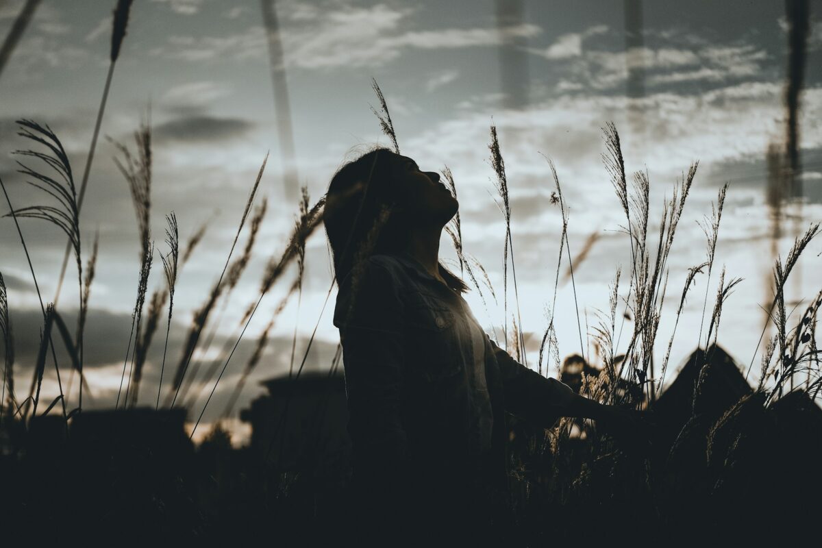 Woman in nature reflecting, representing learning how to start loving yourself.