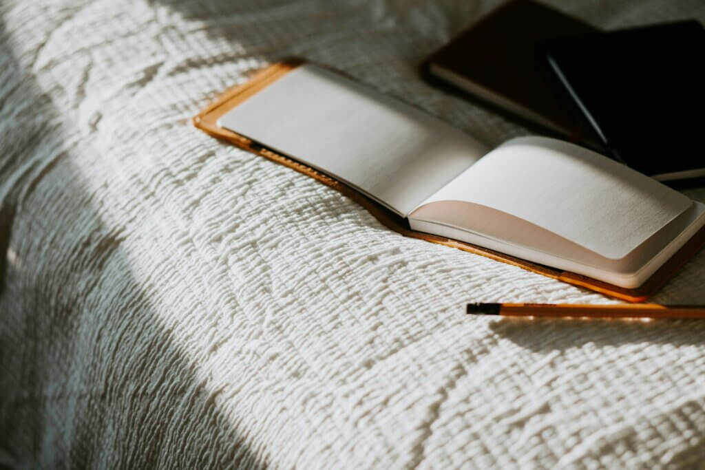 An open journal on the bed, representing journaling for self esteem.
