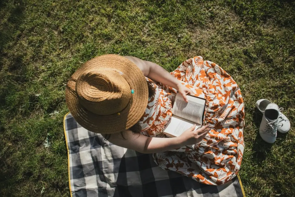 Woman in the park, reading the best books for motivation.