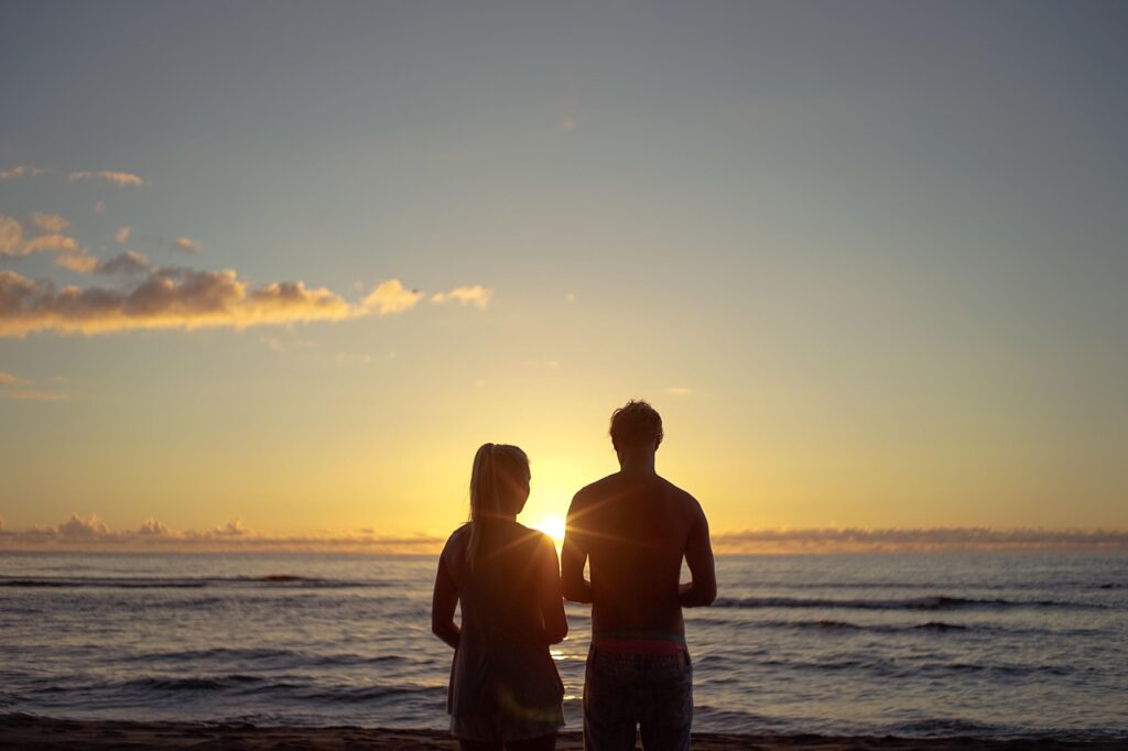 A couple on the beach after learning how to manifest love into your life.