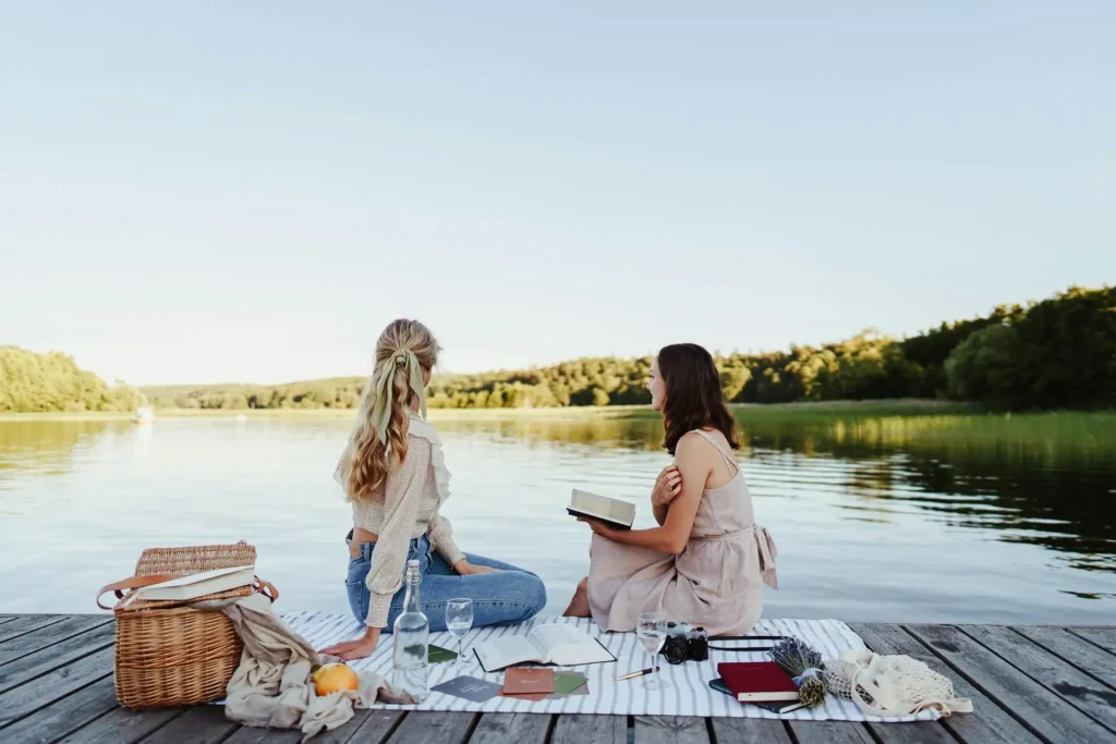 Friends relaxing by the lake after learning about the best summer activities with friends.