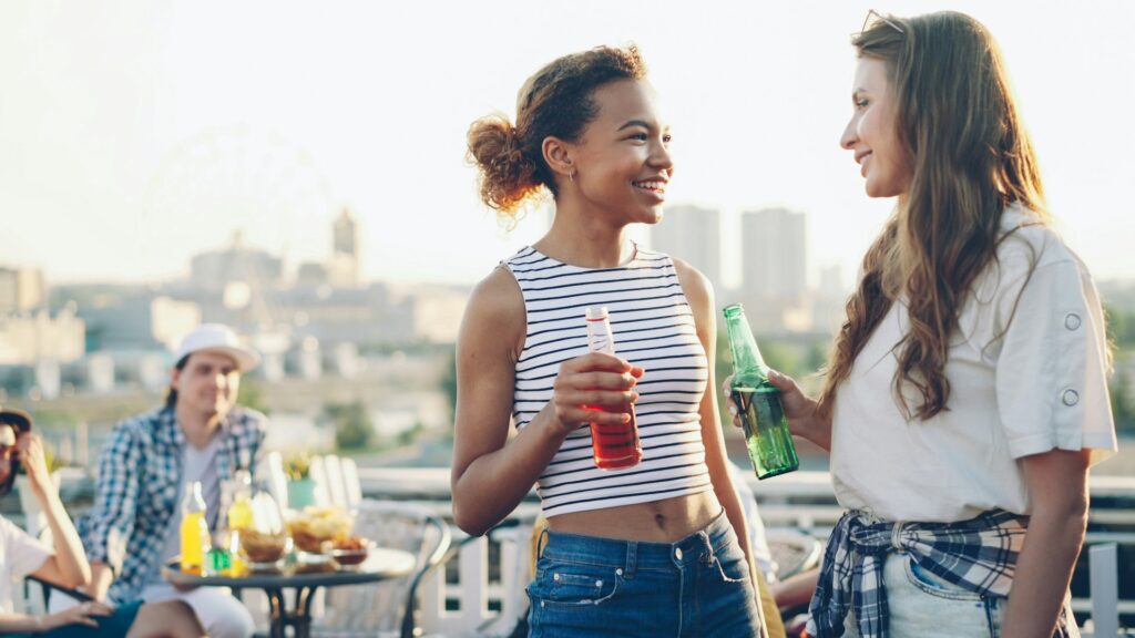 2 women talking on a rooftop party.