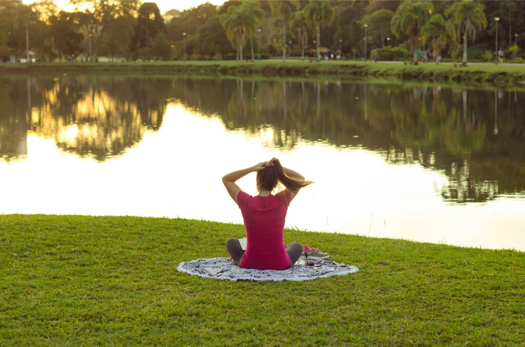 Woman in a park, enjoying the nature after going through a digital detox plan.