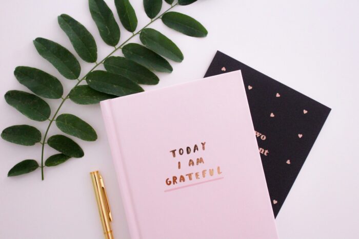 A gratitude journal on a desk, representing a place to practice gratitude journal prompts for adults.