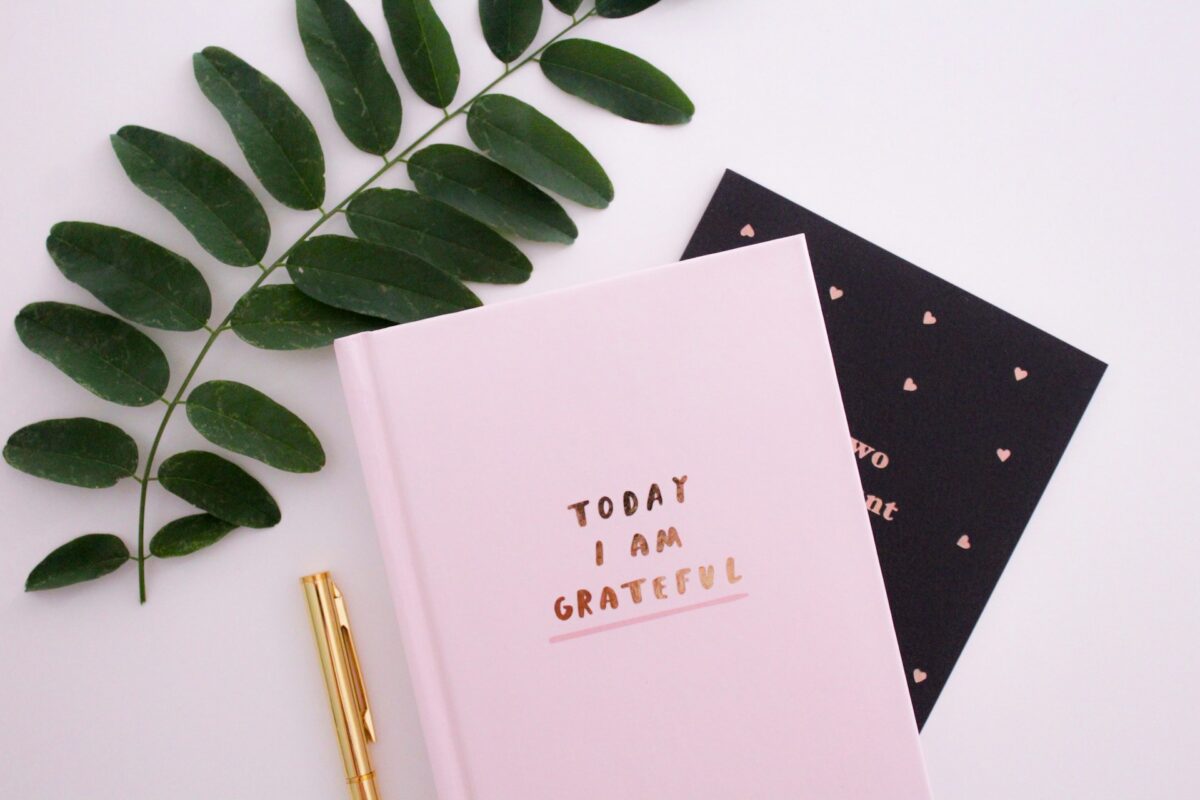 A gratitude journal on a desk, representing a place to practice gratitude journal prompts for adults.