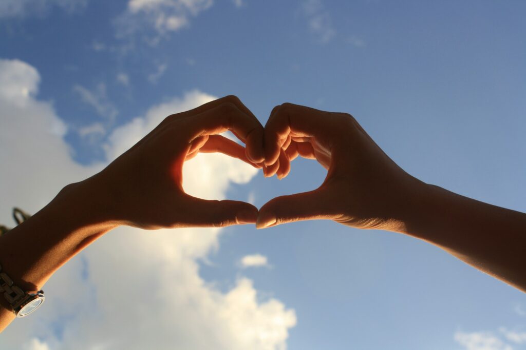 Hands holding a heart shape, representing gratitude after practicing gratitude journal prompts for adults.