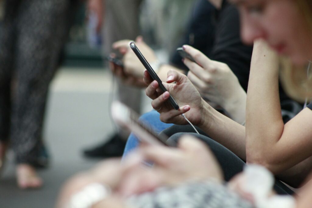 Person scrolling on their phone in a crowd.