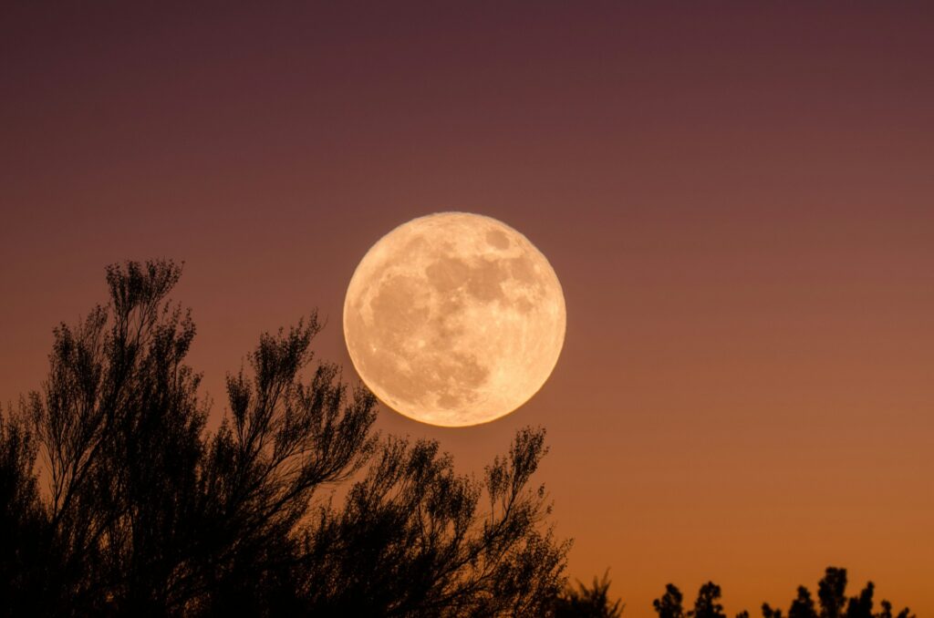 Full moon in the orange sky, representing the full moon release ritual.
