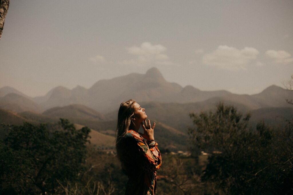 A woman holding her hands together at her heart, representing trusting the universe.